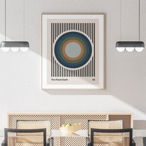 May include: A minimalist poster with a black and white striped background and a concentric circle design in shades of blue, green, and brown. The text "The Planet Earth" and "03" are printed at the bottom of the poster.
