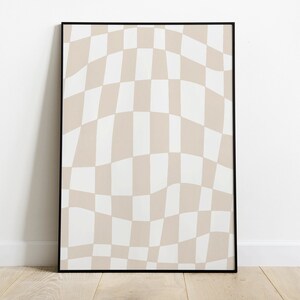 May include: A black framed print featuring a wavy checkered pattern in beige and white.
