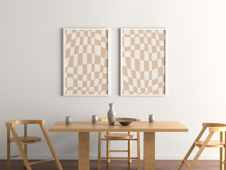 May include: Two framed prints with a beige and white checkered pattern hang above a wooden dining table with four chairs. The table is set with a vase, bowls, and glasses.