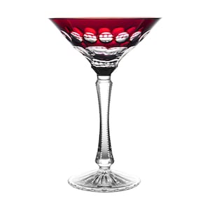 Op de afbeelding: Een helder kristallen martiniglas met een robijnrode rand en een decoratief patroon. De steel is getextureerd en de voet is breed en helder. Het glas is ontworpen voor cocktails en andere dranken.