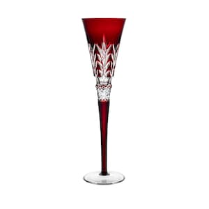 Pode incluir: Uma taça de champanhe alta de vidro transparente com um caule e uma base de cristal vermelho. A taça tem um design decorativo de vidro cortado.