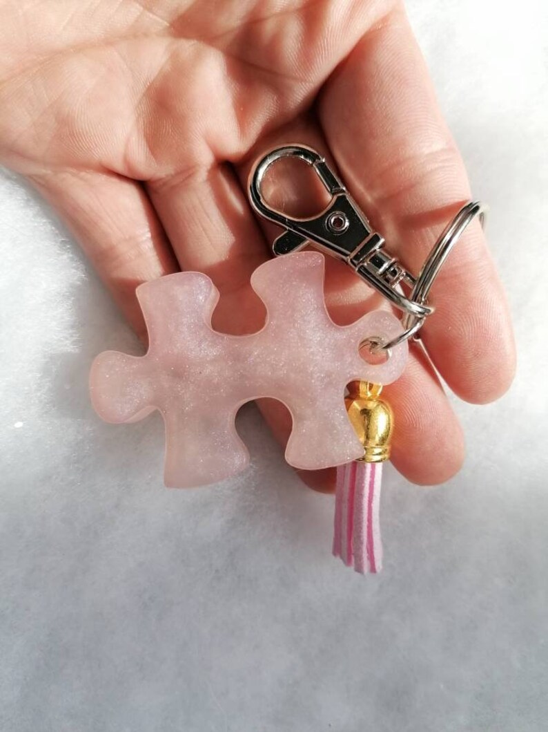 Jigsaw piece keychain with tassle and clip.