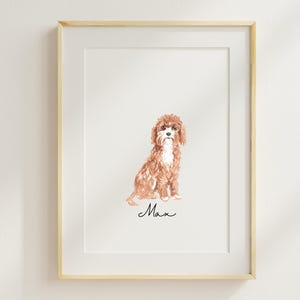 Op de afbeelding: Een ingelijst aquarel schilderij van een bruine en witte hond die zit. De naam van de hond, "Max", staat onder de afbeelding.