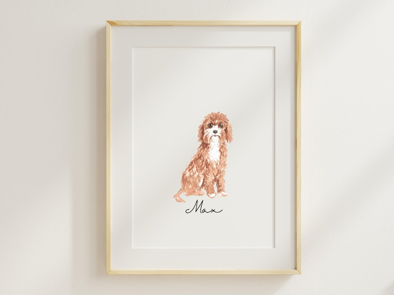 Op de afbeelding: Een ingelijst aquarel schilderij van een bruine en witte hond die zit. De naam van de hond, "Max", staat onder de afbeelding.