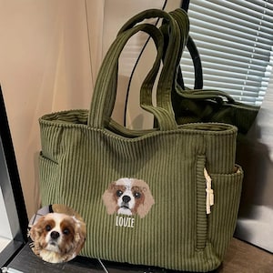 May include: Olive green corduroy tote bag with two handles and side pockets. The bag features an embroidered Cavalier King Charles Spaniel with the name "Louie" below. The brand name "PETCREATIVO" is above the dog.