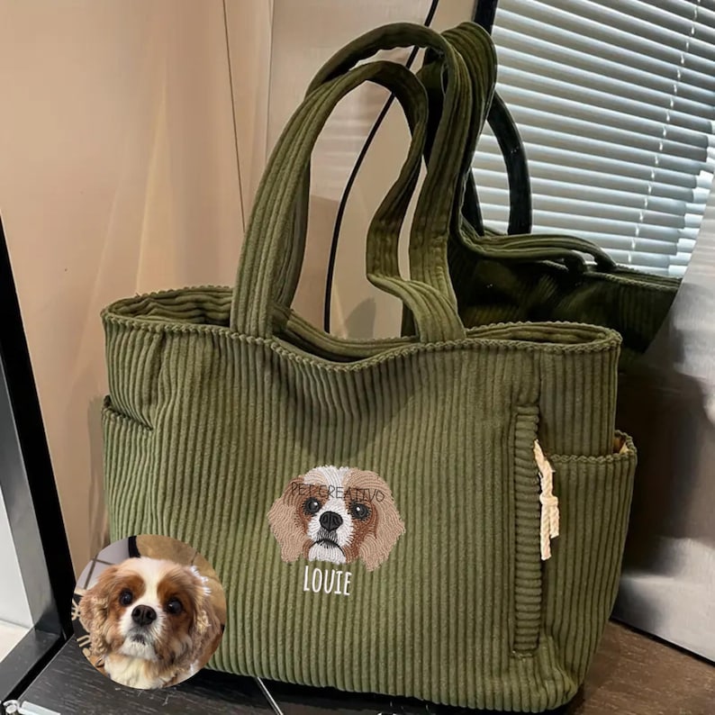 May include: Olive green corduroy tote bag with two handles and side pockets. The bag features an embroidered Cavalier King Charles Spaniel with the name "Louie" below. The brand name "PETCREATIVO" is above the dog.
