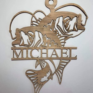 May include: Wooden wall hanging with a silhouette of two fish and the name "MICHAEL" in a decorative font.