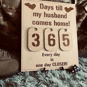 Könnte beinhalten: Ein hölzernes Countdown-Schild mit dem Text "Days till my husband comes home!" und den Zahlen "365". Das Schild hat auch den Text "Every day is one day CLOSER!"