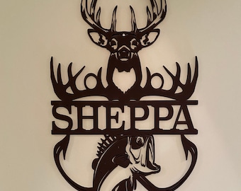 May include: Black metal wall art featuring a deer head with antlers, a fish, and the name "SHEPPA" in a split-letter design.