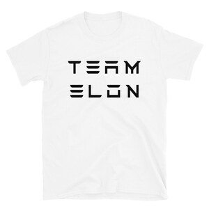 Op de afbeelding: Wit T-shirt met korte mouwen met zwarte tekst die "TEAM ELON" in een gestileerd lettertype leest.