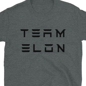 Op de afbeelding: Een heidekleurig T-shirt met de tekst "TEAM ELON" in zwart gedrukt.
