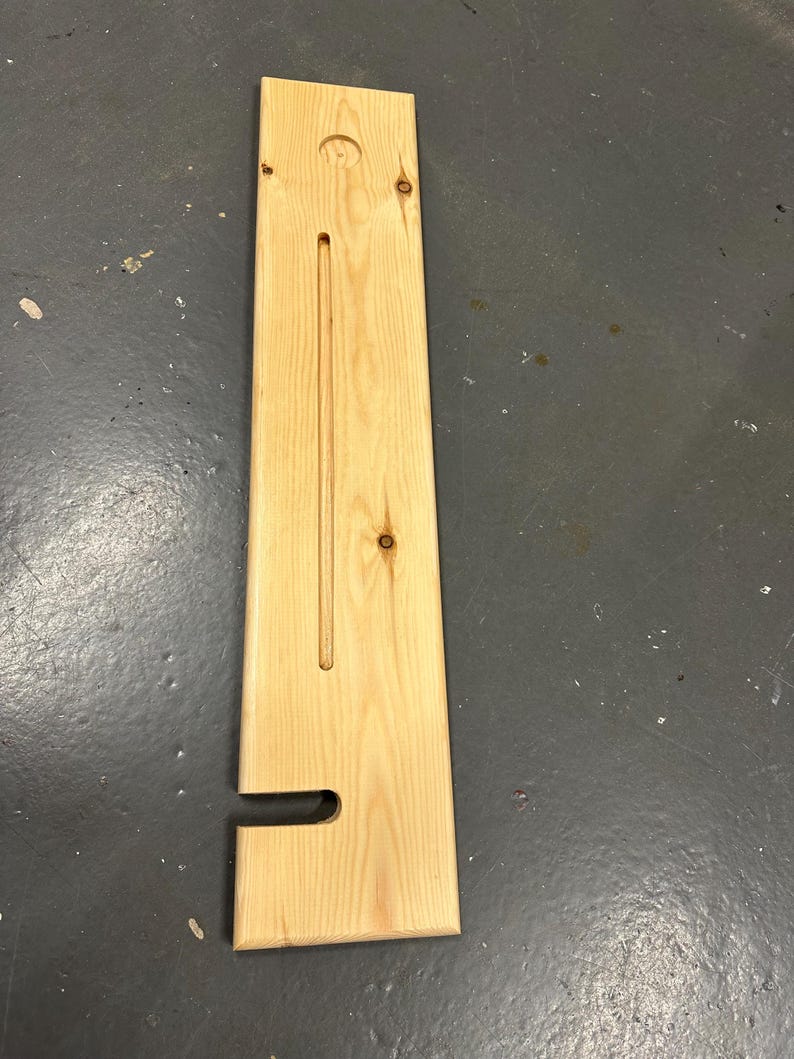May include: A wooden shelf with a cutout for a soap dispenser and a groove for a bar of soap. The shelf is made of light wood and has a natural finish.