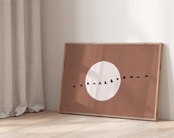 May include: A framed print with a minimalist design featuring a white circle and a line of black birds flying across a terracotta background. The print is titled "Daring Dutch Designers".