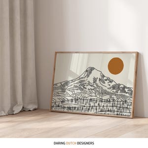 May include: A framed art print featuring a mountain landscape with a sun. The artwork is a line drawing in black on a cream background. The frame is made of light-colored wood. The text "DARING DUTCH DESIGNERS" is at the bottom.