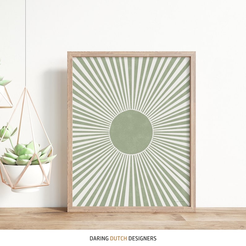 Puede incluir: Una impresi&oacute;n enmarcada con un dise&ntilde;o de rayos de sol verde y blanco. El sol tiene un c&iacute;rculo verde grande en el centro.