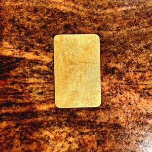 May include: A gold-colored rectangular sign with a textured surface.