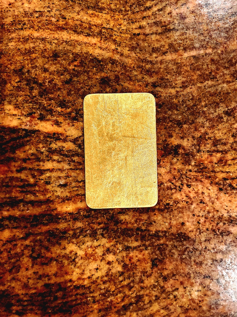 May include: A gold-colored rectangular sign with a textured surface.