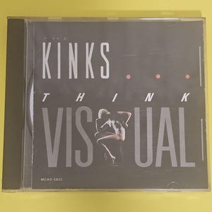 Op de afbeelding: Een zwart-witte CD-hoes met de tekst "KINKS THINK VISUAL" en de albumtitel "MCAD-5822".