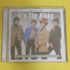 Op de afbeelding: Een CD-hoes met een foto van de band "The Kinks" op de voorkant. De bandleden dragen pakken en staan voor een zilveren achtergrond. De tekst "It's The Kinks" staat in grote letters op de voorkant van de hoes.
