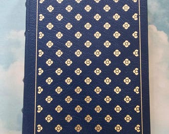 May include: A dark blue hardcover book with a gold floral pattern on the cover.