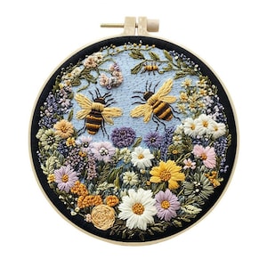 May include: Embroidered hoop art featuring two bees and various flowers in shades of yellow, white, purple, and orange. The bees have brown and yellow stripes. The background is light blue, and the hoop is black.