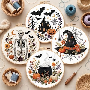 May include: Four circular embroidery hoops featuring Halloween designs on white fabric. One shows a haunted house, bats, and a pumpkin. Another displays a skeleton with flowers and a candle. A third features a witch hat and spiderwebs. The last shows a steaming cauldron with flowers.