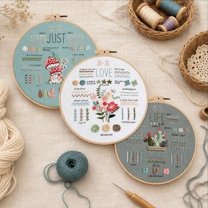 Peut inclure: Trois tambours à broder circulaires en bois présentant des échantillons de points sur tissu. Un tambour affiche des champignons, un autre un bouquet floral et le troisième un cactus. Chaque modèle inclut des noms de points brodés.
