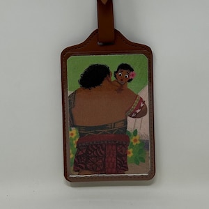 Pode incluir: Uma etiqueta de bagagem com uma al&ccedil;a e fivela de couro marrom. A etiqueta apresenta uma ilustra&ccedil;&atilde;o colorida de um homem segurando uma crian&ccedil;a. O fundo inclui flores e um fundo branco.