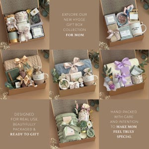 May include: Gift boxes with various items, including mugs, candles, and blankets, are arranged inside. Each box is tied with a ribbon. The text "EXPLORE OUR NEW HYGGE GIFT BOX COLLECTION FOR MOM" is visible.