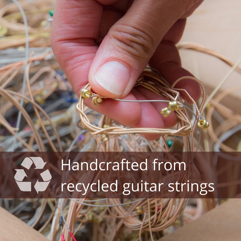 Box of used guitar strings being picked through for recycling into jewelry
