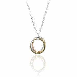 Könnte beinhalten: Eine silberne Kettenkette mit einem Anhänger aus drei ineinander verschlungenen Ringen. Die Ringe sind silber, gold und ein dunkleres Metall.