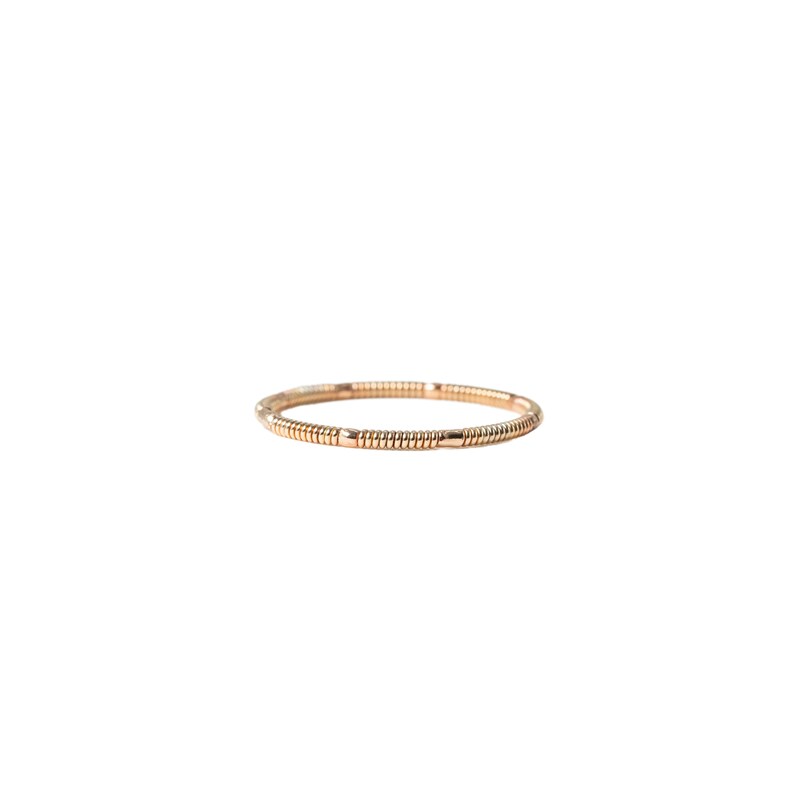 rose gold colored acoustic guitar string ring on white background