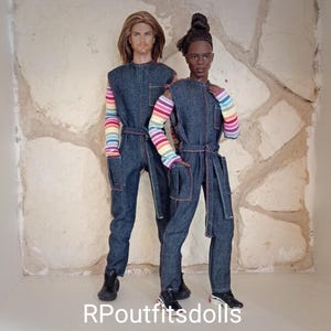 May include: Two dolls wearing denim jumpsuits with rainbow striped sleeves and accents. The jumpsuits have pockets and are cinched at the waist with a matching belt. One doll has long blonde hair, and the other has short black hair. The text "RPoutfitsdolls" is at the bottom.