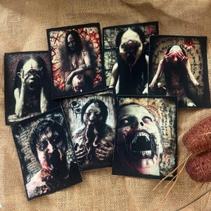 Peut inclure: Une collection d'impressions d'art rectangulaires représentant des figures grotesques ressemblant à des zombies, avec des plaies exposées et des visages déformés. Les images sont sombres avec des accents rouges et blancs, créant un thème d'horreur.