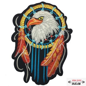 May include: Embroidered iron-on patch featuring a white eagle head inside a yellow dreamcatcher with red and orange feathers. The patch is 17.5 inches by 25 inches.
