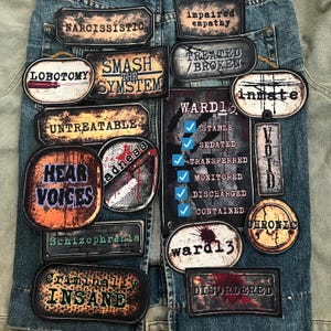 May include: A collection of distressed-style patches with phrases like "Narcissistic," "Lobotomy," and "Hear Voices." The patches are in various shapes and sizes, with a grunge aesthetic, and are affixed to a denim jacket.