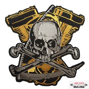 May include: A black, gold, and silver embroidered patch featuring a skull and crossbones with a motorcycle engine in the background. The patch measures 26.5 inches by 26.5 inches.