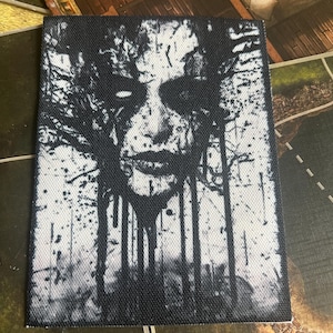 May include: Black and white graphic print of a face with branches growing from it. The face is surrounded by a dark background and the branches are white.