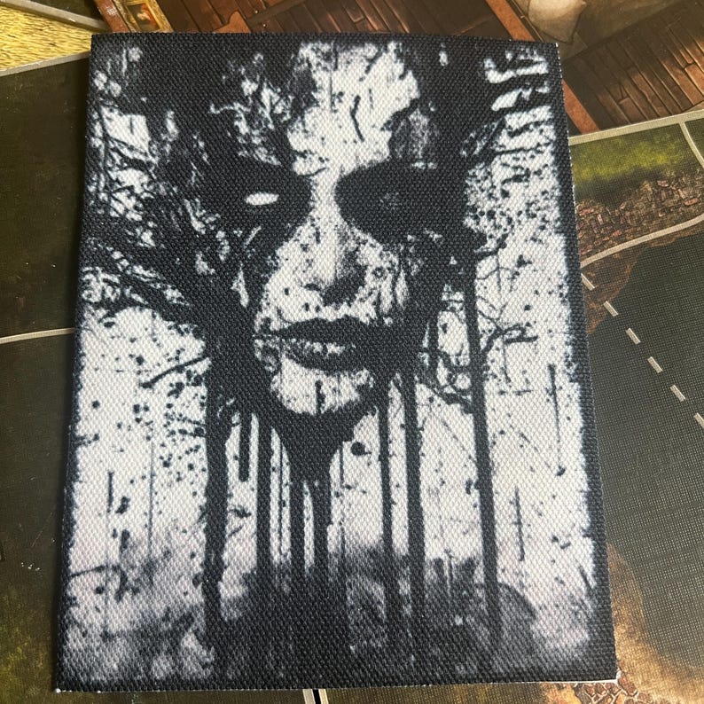 May include: Black and white graphic print of a face with branches growing from it. The face is surrounded by a dark background and the branches are white.