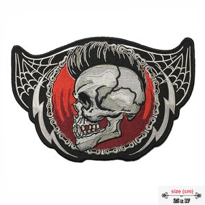 May include: Black and red embroidered iron-on patch featuring a skull with a pompadour hairstyle, surrounded by a chain and lightning bolts. The skull is set against a red background with flames. The patch measures 25 x 17 cm.