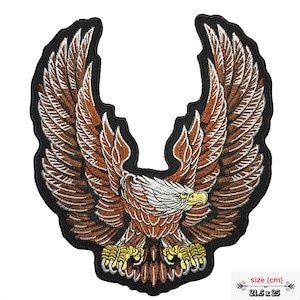 Könnte beinhalten: Gestickter Aufnäher mit einem braunen Adler mit weißem Kopf und gelbem Schnabel, die Flügel weit ausgebreitet, auf schwarzem Hintergrund. Der Aufnäher misst 21,5 cm x 25 cm.