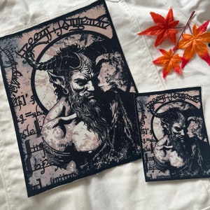 May include: Two black and white iron-on patches with a graphic of a horned, bearded man with a dark background. The text "Heavy Metal" is written in a gothic font around the man's head.