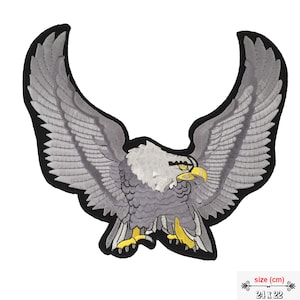 May include: Embroidered patch of a grey eagle with outstretched wings, featuring a white head and yellow beak and talons. The patch is outlined in black. The size is 24 x 22 cm.