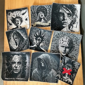 May include: Nine black and white embroidered patches featuring various horror-themed images, including a hooded figure, a skull, a creature with horns, and a face with spikes. The patches have white stitching around the edges and some have text, including "Hell Admission" and "Censor".
