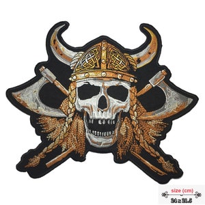 May include: Embroidered iron-on patch featuring a skull wearing a horned Viking helmet with crossed axes behind it. The patch is black with gold, silver, and brown accents. The patch measures 24 x 21.5 cm.