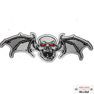 Può includere: Una toppa ricamata grigia con un teschio con occhi rossi e ali di pipistrello. La toppa misura 8,9 cm per 31,8 cm.