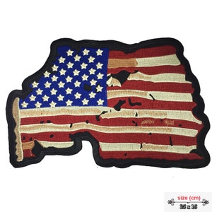 May include: Distressed American flag patch with a black border. The flag is red, white, and blue with a faded look. The patch is 25 x 15 cm.