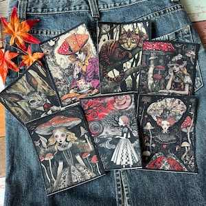 May include: Six illustrated patches featuring characters from Alice in Wonderland. The patches are on a blue denim background. The characters include the Mad Hatter, the Cheshire Cat, the White Rabbit, Alice, the Queen of Hearts, and the March Hare.
