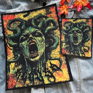 May include: A large, colorful patch with a screaming Medusa head surrounded by snakes. The background is a yellow, orange, and red gradient with black and green accents. The patch has a distressed, vintage look.