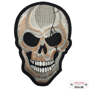 Könnte beinhalten: Gestickter Bügel-Patch mit einem weißen Totenkopf mit schwarzem Augenklappen. Der Schädel hat ein rissiges Design und ein zahniges Grinsen. Der Patch misst 17,5 cm x 25 cm.